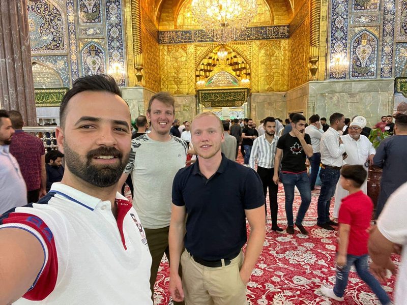 Ali Babylon tour guide taking a selfie with two Western tourists inside the golden Imam Ali Shrine in Najaf, Iraq