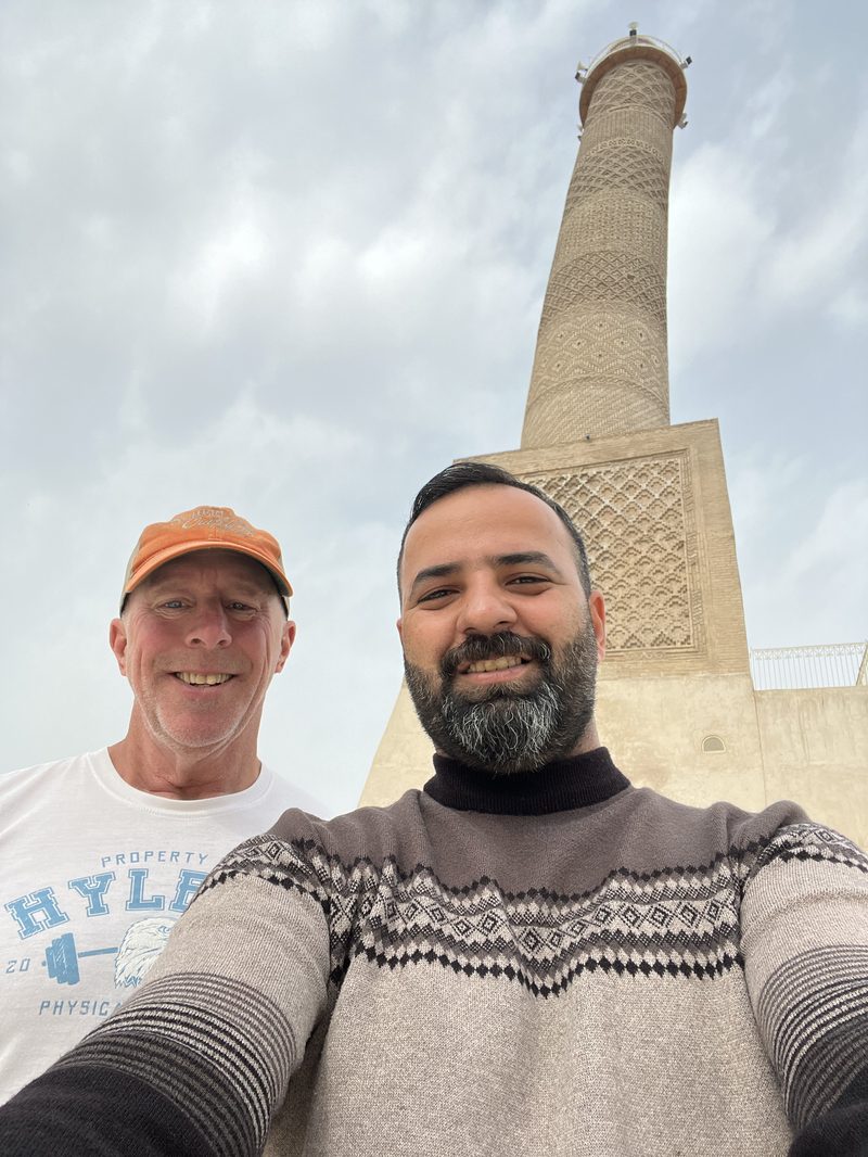 Selfie of Ali Babylon tour guide Ali and a Western tourist smiling in front of the Al-Hadba minaret in Mosul, Iraq