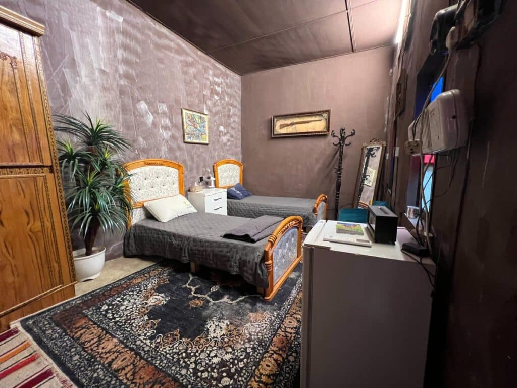 Guest bedroom at Ali Babylon Tours guesthouse in Baghdad with twin beds and Persian carpet