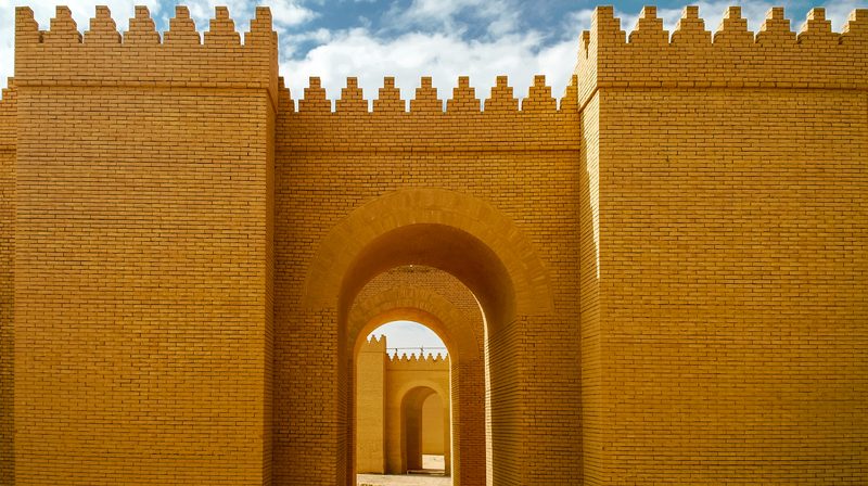 Reconstructed ancient Babylon brick walls with arched gateway passage, Iraq