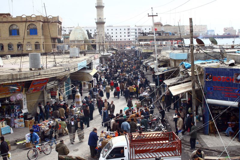 Crowded bazaar street market with vendors and shoppers in Basra, Iraq