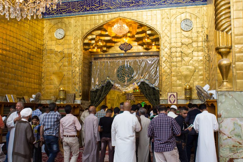 Pilgrims praying inside the golden interior of the Imam Ali shrine in Najaf, Iraq