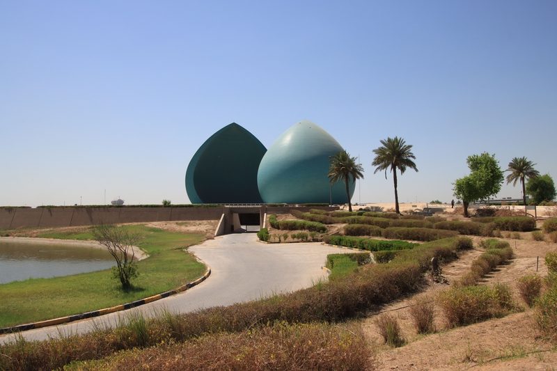 The turquoise split-dome Martyr Monument memorial surrounded by gardens in Baghdad, Iraq