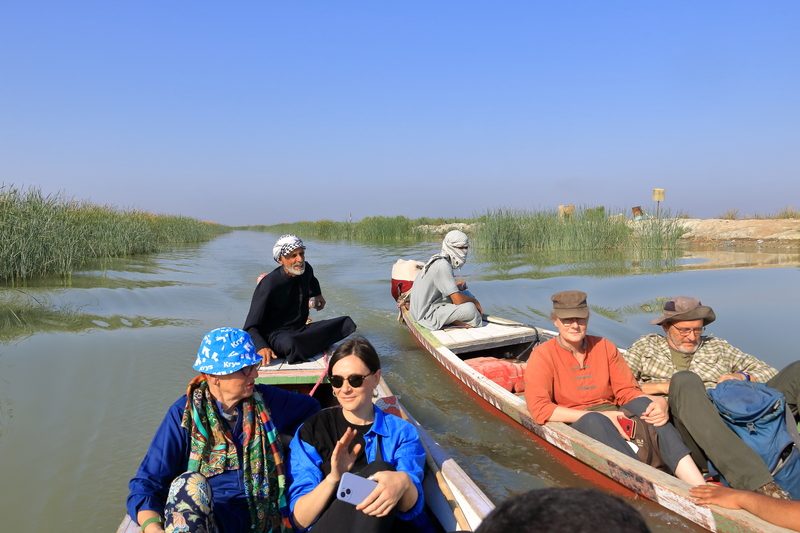 Two happy tourists enjoying a traditional Iraqi barbecue dinner with flatbread and mezze dishes at a local restaurant in Iraq