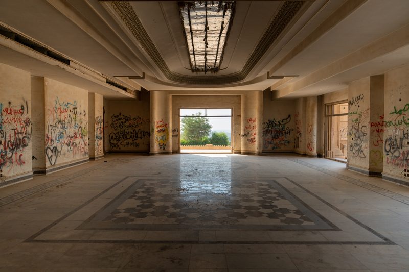 Vast abandoned interior hall of Saddam Hussein's palace covered in graffiti, Baghdad, Iraq